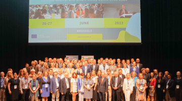 A large group of represenatives of the Cities Mission standing together on stage for a group photo