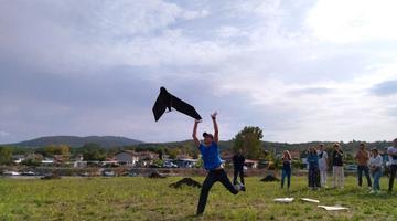 A person is on a field letting go of a drone