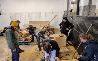 A group of of people doing different things in a workshop