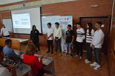A group of students are presenting inside a large classroom