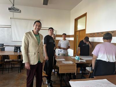 People surrounding a table with some smiling for the camera