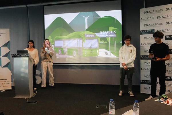 four young people presenting from stage