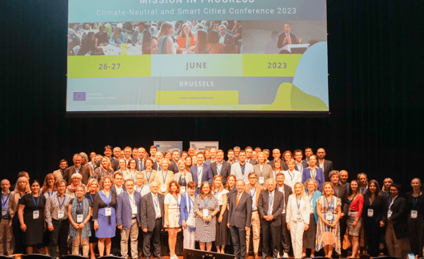 A large group of represenatives of the Cities Mission standing together on stage for a group photo