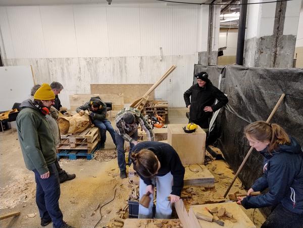 A group of of people doing different things in a workshop
