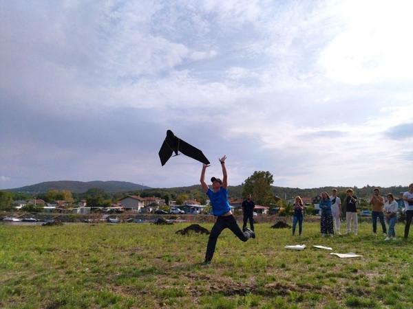 A person is on a field letting go of a drone